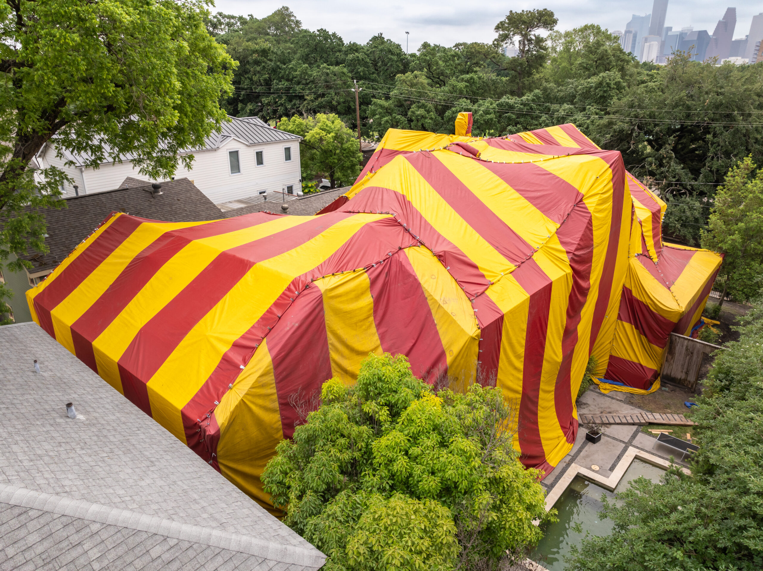 Yellow and red fumigation tent over a house in a neighborhood